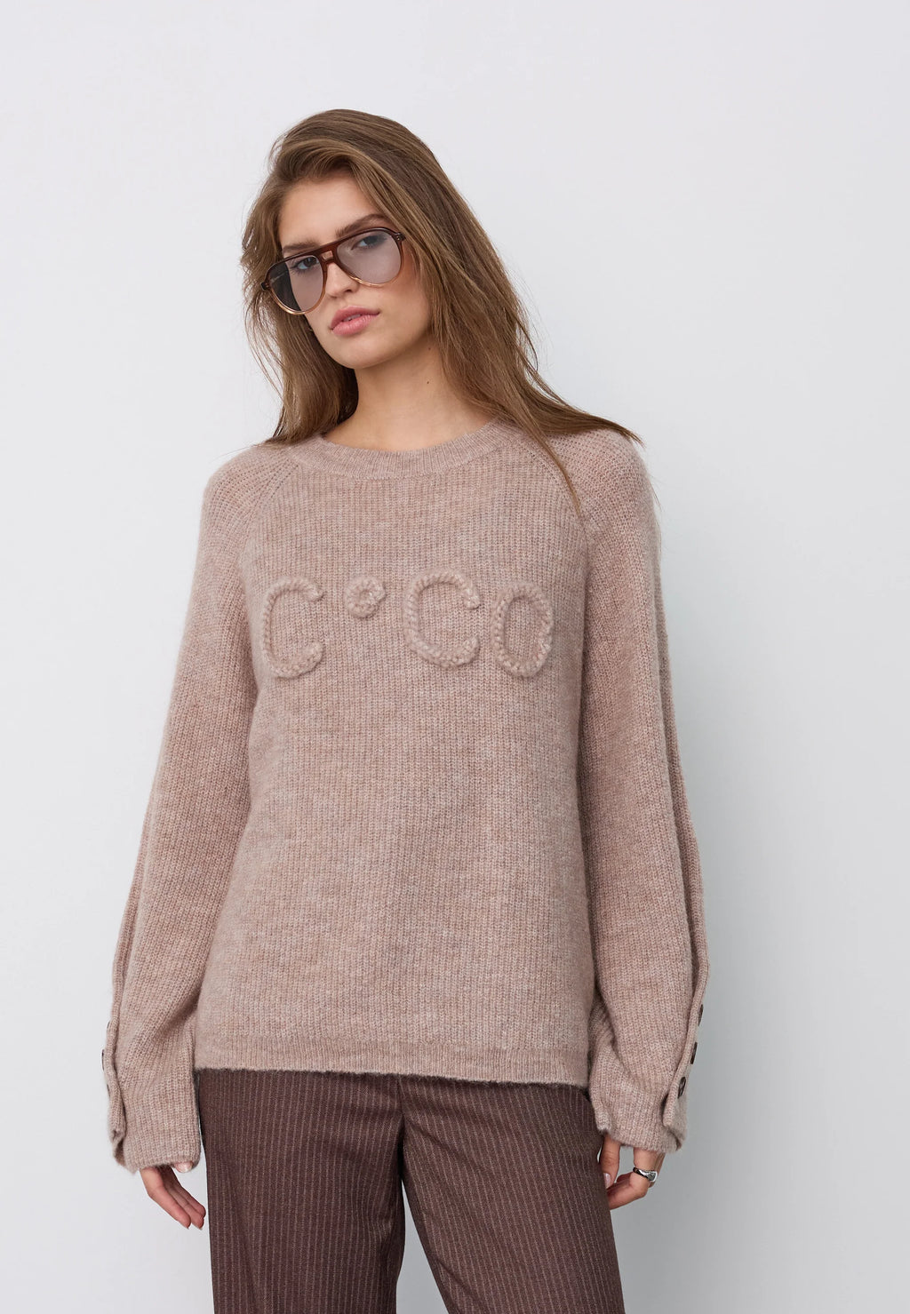 Co’Couture AelleCC Knit -neulepusero ruskeassa Walnut-sävyssä. Väljä istuvuus, kirjailtu teksti rinnassa ja koristenapit hihansuissa.