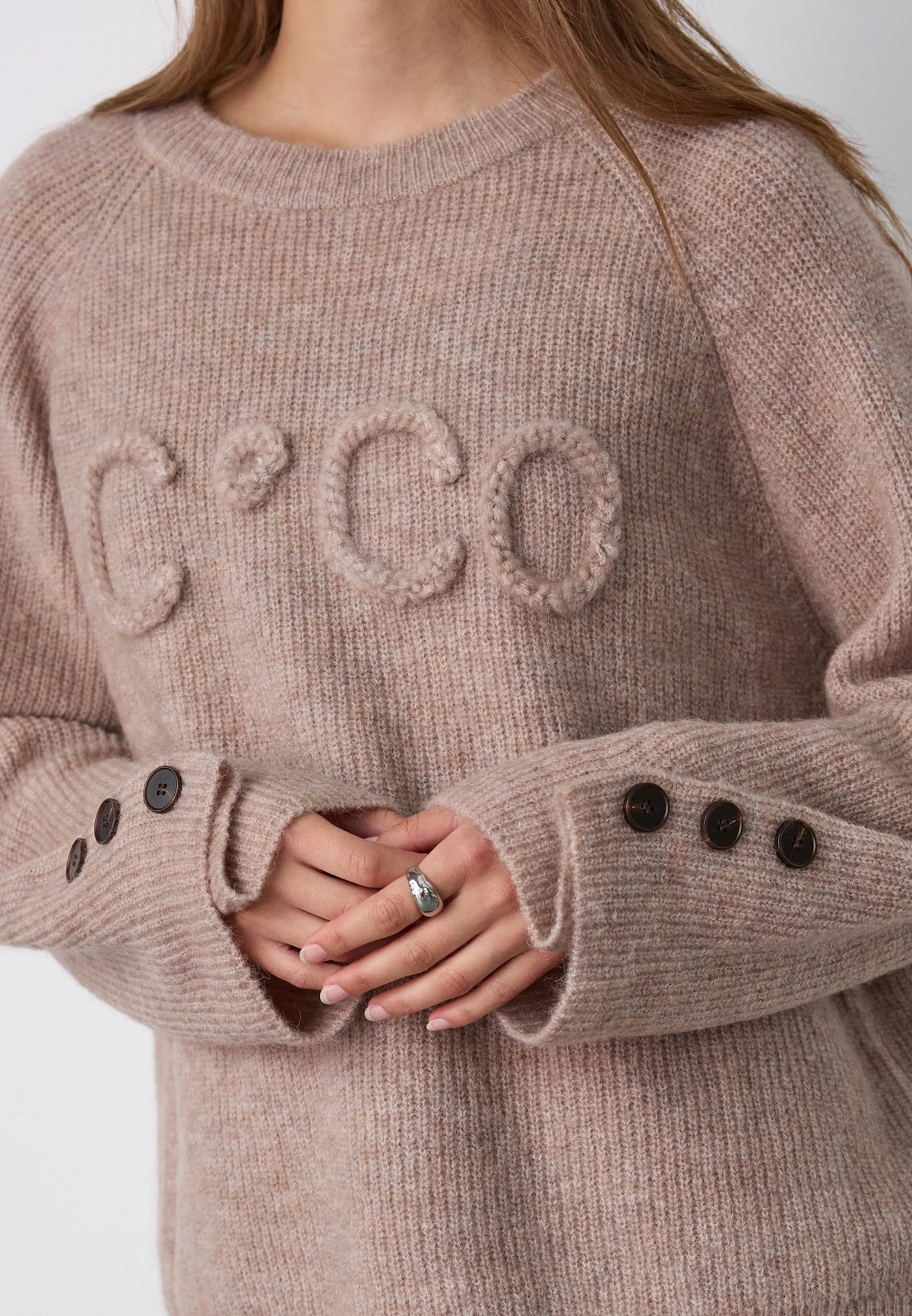Co’Couture AelleCC Knit -neulepusero ruskeassa Walnut-sävyssä. Väljä istuvuus, kirjailtu teksti rinnassa ja koristenapit hihansuissa.