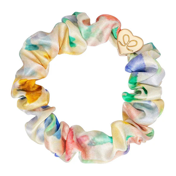 byEloise Silk Scrunchie on kaunis hiusasuste, jossa yhdistyvät ylellinen silkkimäinen materiaali ja kullanvärinen koriste. Pehmeä pompula on hellävarainen hiuksille ja viimeistelee kampauksen tyylikkäällä tavalla.