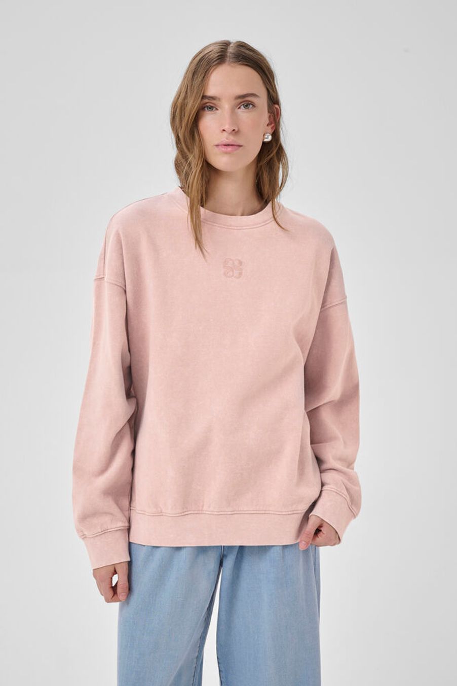 Tämä ihanan rento collegepusero hurmaa pehmeällä materiaalillaan ja kauniilla adobe rose washed -sävyllään. Hieman kulutettu väripinta tuo paitaan elävyyttä ja tekee ilmeestä rennon trendikkään.