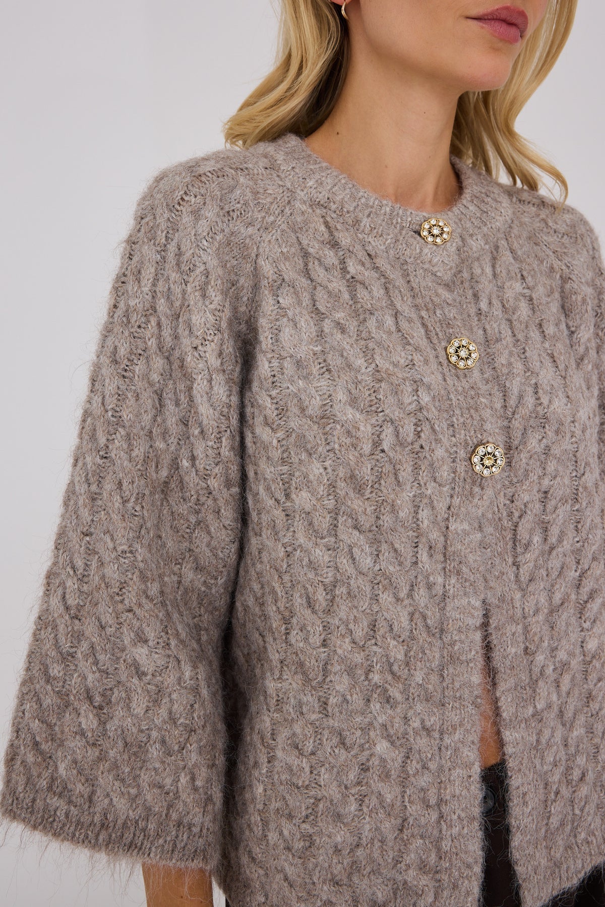 Kabba Knit Cardigan on pehmeä oversized-neuletakki, jossa on kaunis palmikkoneulos, näyttävät balloon-hihat ja koristeelliset helmiäisnapit.