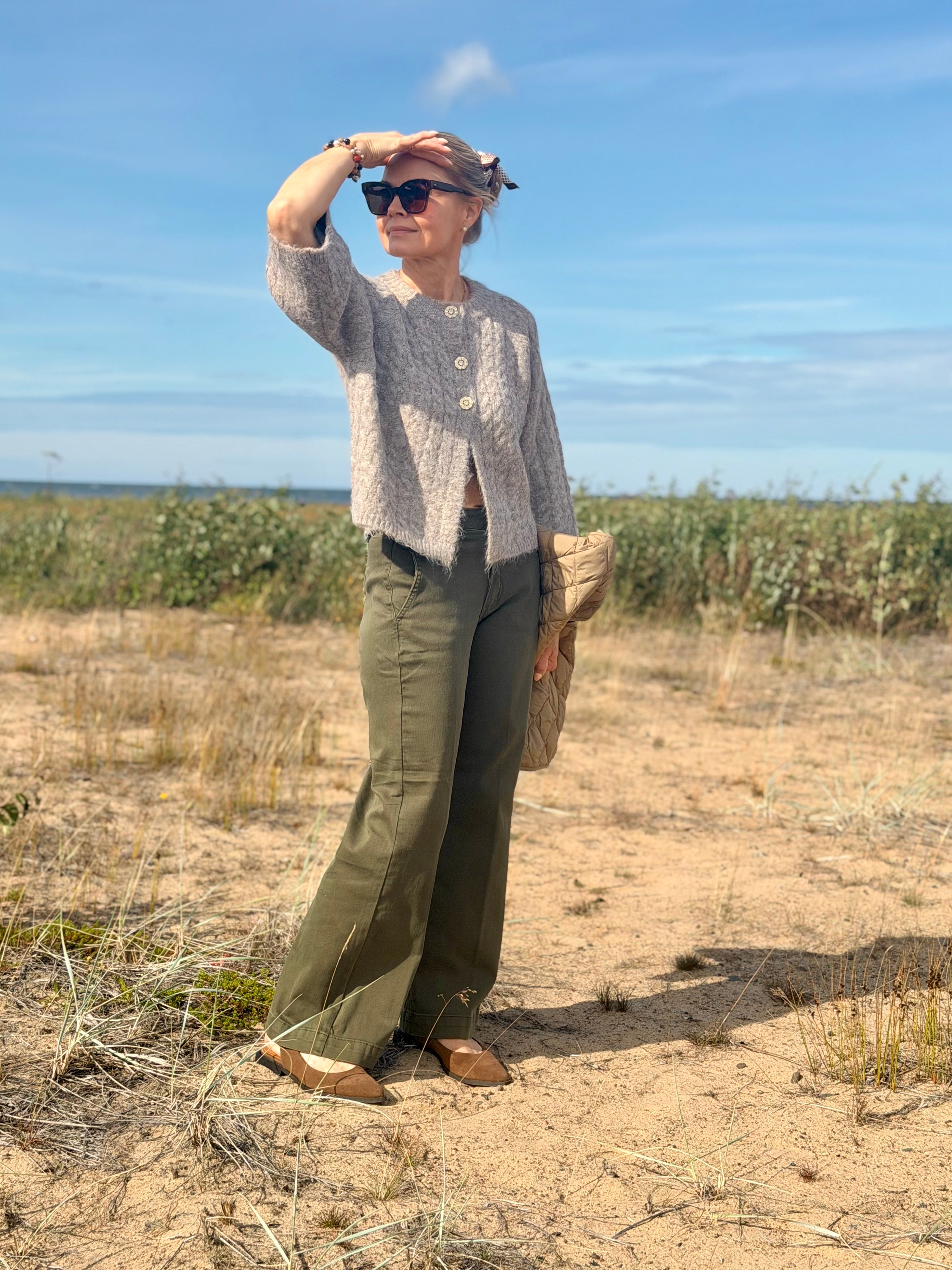 Kabba Knit Cardigan on pehmeä oversized-neuletakki, jossa on kaunis palmikkoneulos, näyttävät balloon-hihat ja koristeelliset helmiäisnapit.