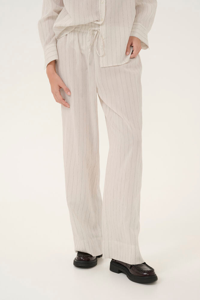 LimaMW Wide Pant -housut ovat täydellinen valinta kesän huolettomaan pukeutumiseen. Kevyesti laskeutuva materiaali ja hillitty raitapinta tuovat housuihin raikasta ilmettä, joka toimii niin arjessa kuin lomatunnelmissa.