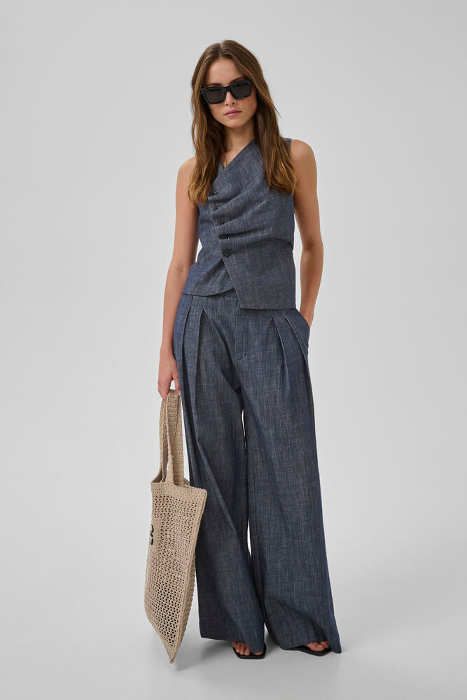 Tummansininen farkkuliivi, epäsymmetrisellä nappikiinnityksellä. Kaunis ja naisellinen istuva malli.