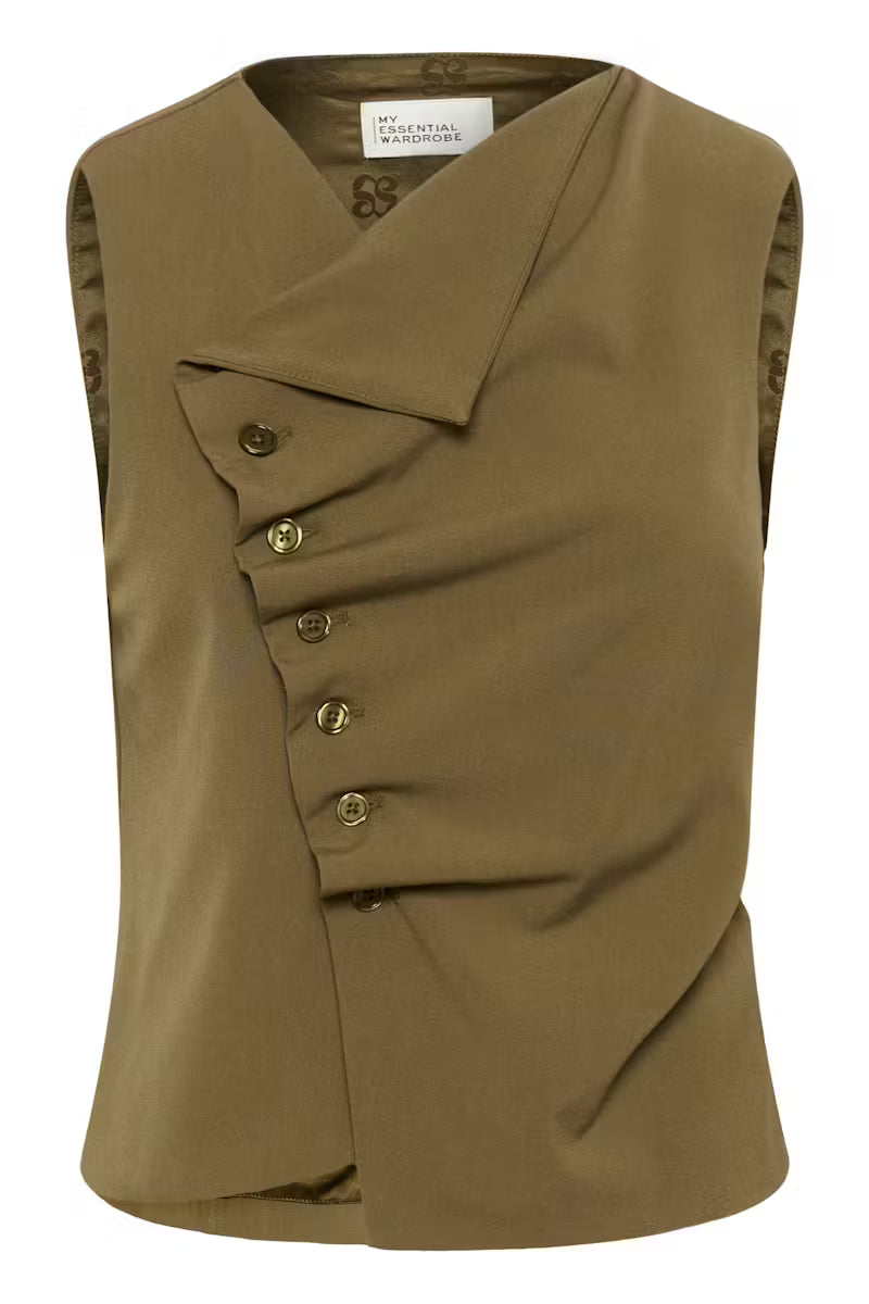 Tämä naisellinen hihaton toppi yhdistää modernin ilmeen ja arjen käyttömukavuuden. Epäsymmetrinen nappikiinnitys ja kauniisti istuva rypytetty etuosa tuovat paidalle hauskaa ilmettä.