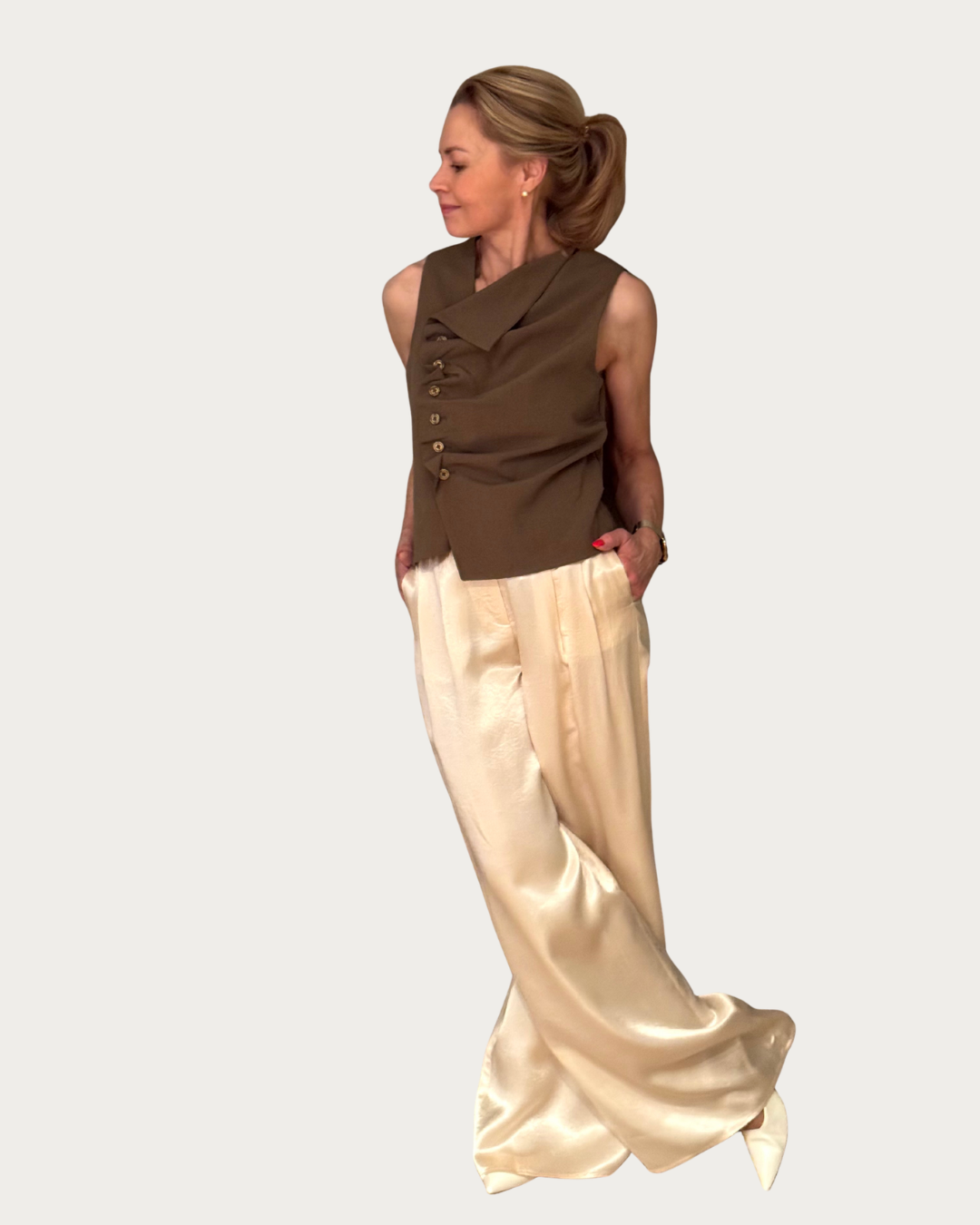 Tämä naisellinen hihaton toppi yhdistää modernin ilmeen ja arjen käyttömukavuuden. Epäsymmetrinen nappikiinnitys ja kauniisti istuva rypytetty etuosa tuovat paidalle hauskaa ilmettä.