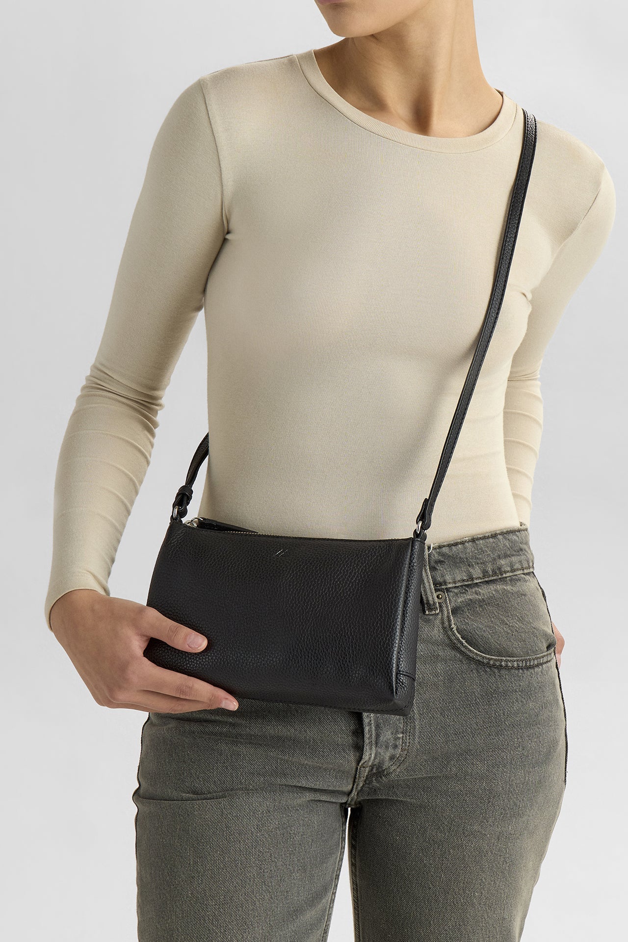 Markberg MarciMBG on kompakti musta nahkalaukku, säädettävällä crossbody-hihnalla. Vetoketjukiinnitys ja sisätasku pitävät tärkeät tavarat mukana. Katso lisää!