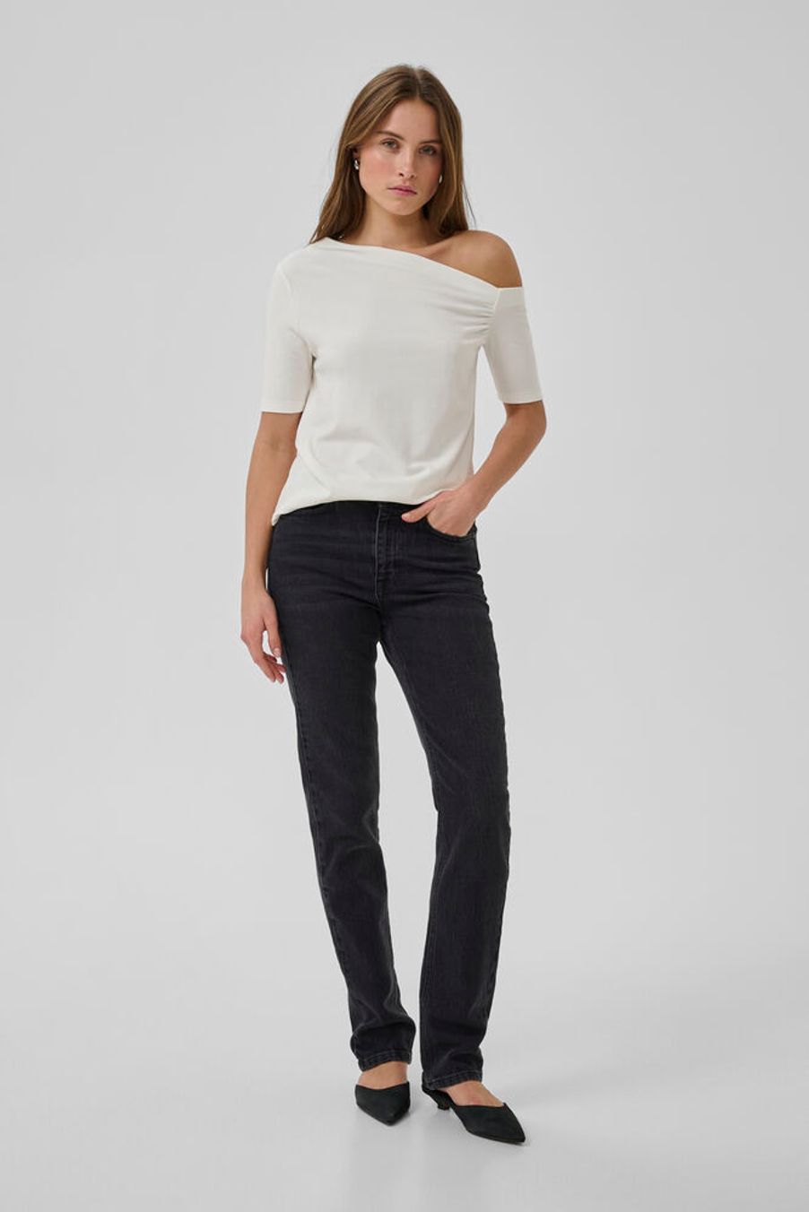 My Essential Wardroben t-paita tuo särmää ja naisellisuutta arkeen ja juhlaan. Epäsymmetrinen, olkapään paljastava pääntie ja slim fit -leikkaus luovat kauniin siluetin. Vasemmassa hihassa oleva rypytys tuo kiinnostavaa yksityiskohtaa ja viimeistelee ilmeen.