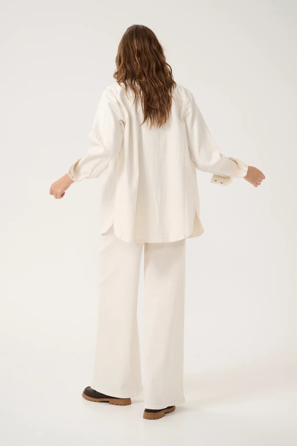 Tämä luonnonvalkoinen farkkupaita on trendikäs ja monikäyttöinen perustuote, joka kuuluu jokaisen vaatekaappiin. Pehmeä kangas tuntuu miellyttävältä päällä ja istuu kauniisti, ilman että se tuntuisi tiukalta.