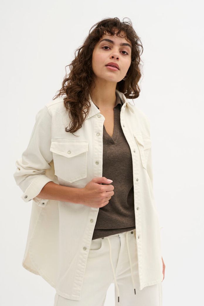 Tämä luonnonvalkoinen farkkupaita on trendikäs ja monikäyttöinen perustuote, joka kuuluu jokaisen vaatekaappiin. Pehmeä kangas tuntuu miellyttävältä päällä ja istuu kauniisti, ilman että se tuntuisi tiukalta.