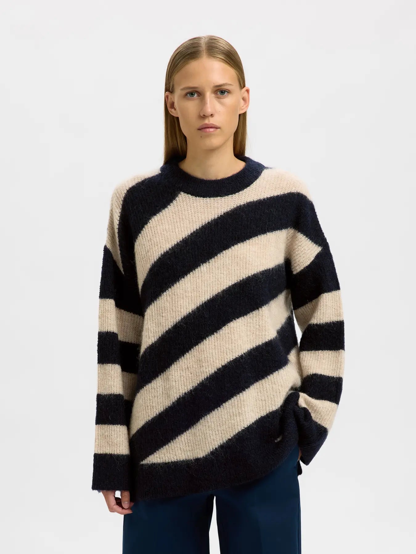 SELECTED FEMME Almina on pehmeä raidallinen oversize-neulepoolo villa- ja mohairsekoitteesta. Dark Sapphire ja hiekka tekevät ilmeestä ajattoman.