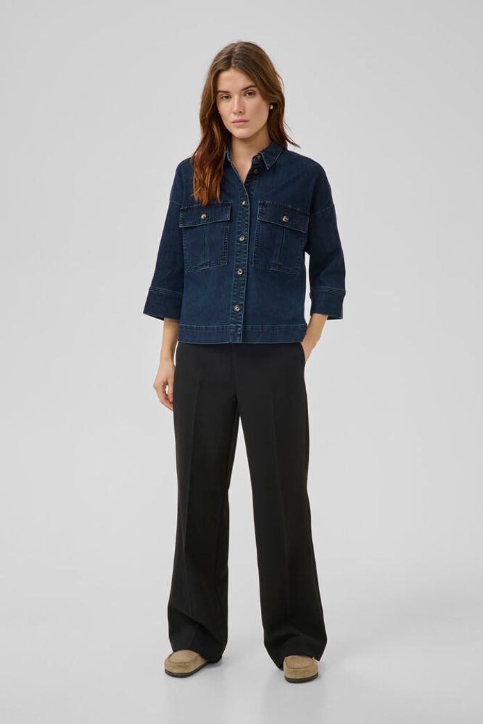 Tämä tummansininen paitajakku yhdistää rentouden ja tyylikkyyden täydellisesti. Suora ja hieman väljähkö malli tekee takista mukavan kerrospukeutumiseen, ja lyhyehkö helma tuo modernia ilmettä.