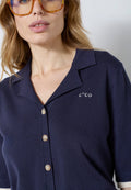 Co’Couture LueCC Crop Cardigan on lyhyt tummansininen neuletakki, jossa on kaulus, lyhyet hihat ja nappikiinnitys. Väljä malli sopii helposti kerrostamiseen.