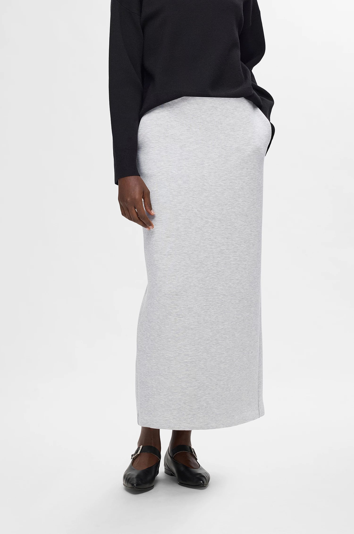 Tämä pitkä jämäkkä trikoinen hame yhdistää mukavuuden ja huolitellun ilmeen. Joustava materiaali sekä korkea vyötärö tekevät hameesta erittäin miellyttävän päällä ja helposti istuvan. Selkeä, pitkä linja tuo asuun tyylikkyyttä, mutta joustava kangas pitää kokonaisuuden rennon tuntuisena.