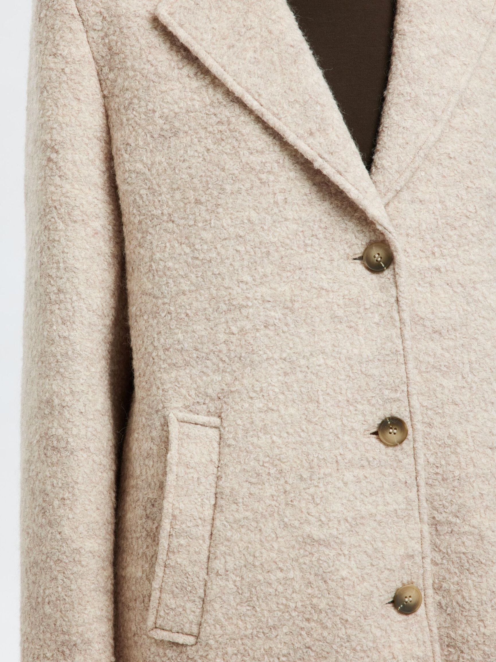 Tämä villasekoitteinen bouclé-takki on ajaton klassikko, joka kuuluu jokaisen naisen vaatekaappiin. Kauniisti teksturoitu bouclé-kangas tuo takkiin elävyyttä ja hienostuneen ilmeen, samalla kun kaunis leikkaus antaa kokonaisuudelle ryhtiä ja eleganssia.