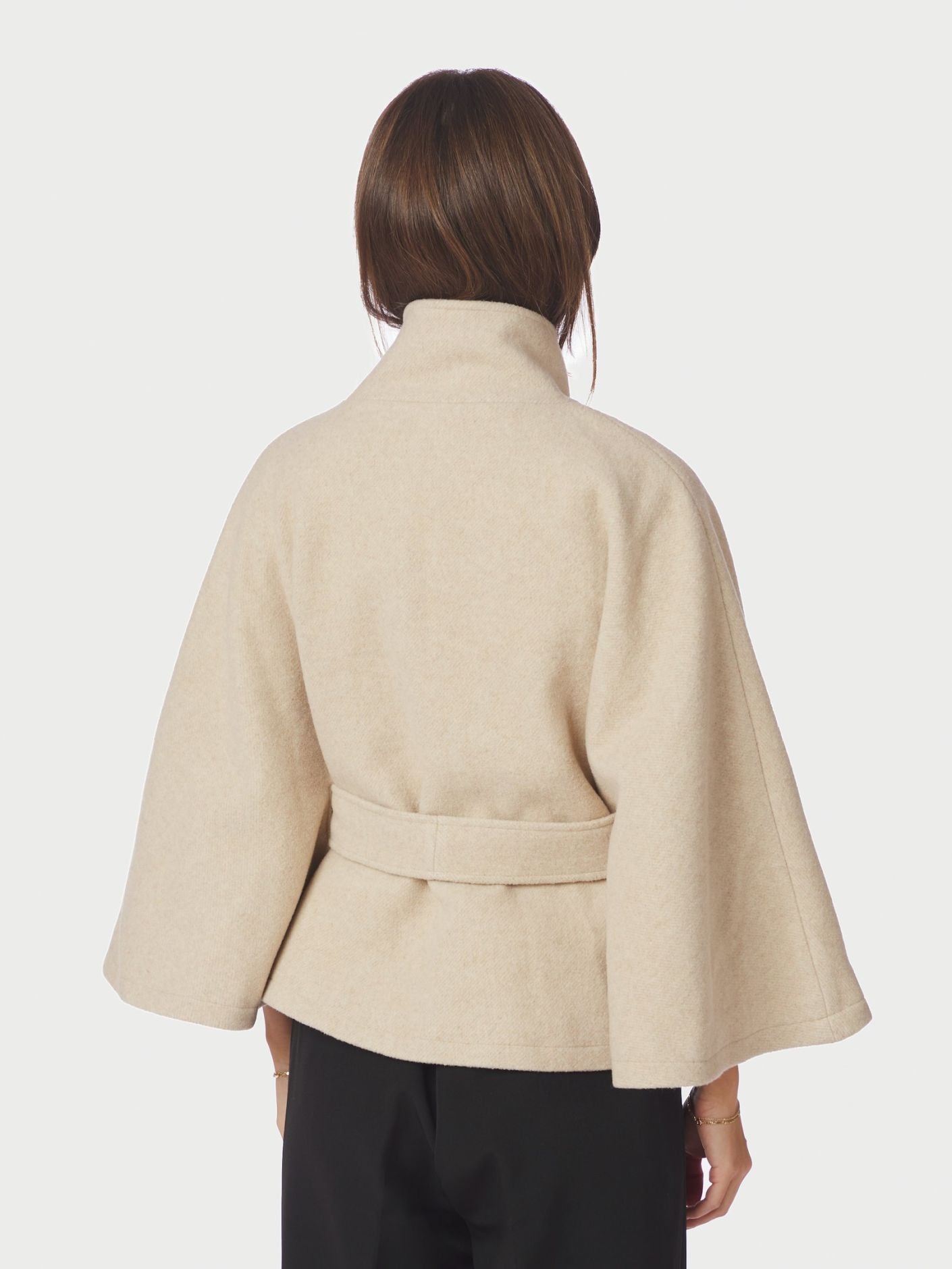 Neo Noir Cape Jacket on tyylikäs lyhyt villasekoitetakki viittamaisella leikkauksella. Korkea kaulus, vyötärövyö ja ajaton hiekan sävy viimeistelevät ilmeen.